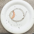 Bracelet with rose gold and silver links on a white speckled plate